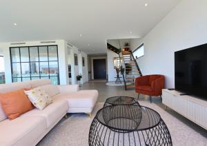 a living room with a white couch and a tv at Villa Pingau in Vila Nova de Gaia