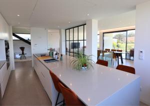 a kitchen with a white counter top and chairs at Villa Pingau in Vila Nova de Gaia