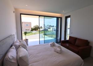 a bedroom with a bed and a couch and a large window at Villa Pingau in Vila Nova de Gaia +58 photos