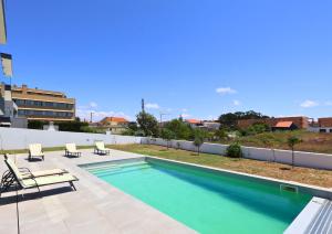 a swimming pool with two lounge chairs and a swimming pool at Villa Pingau in Vila Nova de Gaia