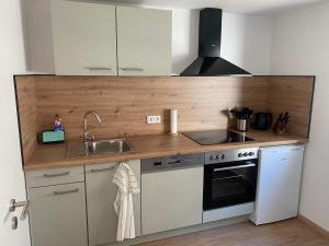 a kitchen with a sink and a stove at Ferienwohnung Sollingseck in Dassel +8 photos