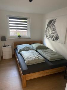 a bed in a bedroom with a picture of a zebra at Ferienwohnung Sollingseck in Dassel