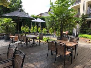 a wooden deck with tables and chairs and umbrellas at Weinquartier Burggarten in Bad Neuenahr-Ahrweiler