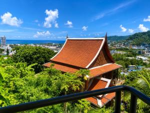 a building with a roof on top of a city at Baan Mon Hill in Patong Beach