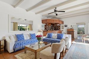 a living room with white furniture and a ceiling fan at Paradiso Guesthouse & Self-catering Cottage in Cape Town