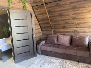 a couch in a room with a wooden wall at Baet Home in Bayetovka
