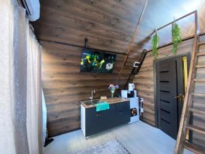 a room with a sink and a tv on a wall at Baet Home in Bayetovka