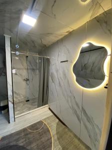 a bathroom with a shower and a marble wall at Baet Home in Bayetovka
