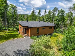 a log cabin in the woods with a driveway at Le Clorane spa relax in Chertsey