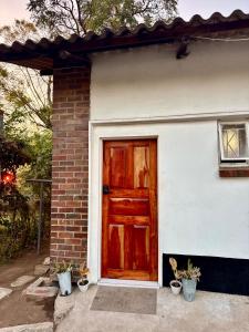 a house with a red door and some potted plants at The Cozy Cottage in Ndola