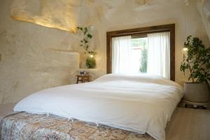 a bedroom with a large white bed with a window at 공간서시 in Chin-dong