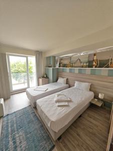 a hotel room with two beds and a large window at Anna ByTheSea By iVAVev in Eforie Sud