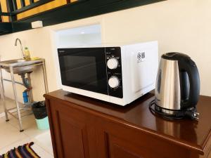 a microwave sitting on top of a wooden cabinet at Baan Mon Hill in Patong Beach