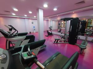 ein Fitnessstudio mit Trainingsgeräten in einem rosa Raum in der Unterkunft Hotel Zenith in Oran