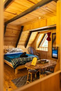 a log cabin bedroom with a bed and a table at El Paraje Cabaña 2 in San Andrés Paxtlán