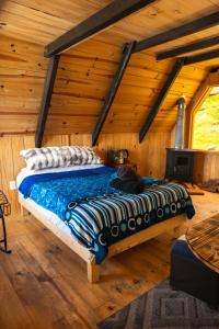 a bed in a room with a wooden ceiling at El Paraje Cabaña 2 in San Andrés Paxtlán