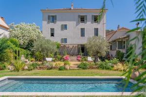 a house with a swimming pool in front of a building at Maison Aimé in La Motte