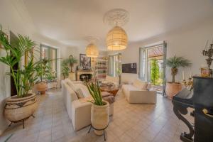 a living room with white furniture and potted plants at Maison Aimé in La Motte