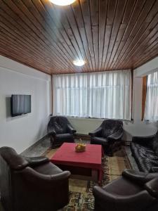 a living room with leather chairs and a red table at Casa Ursilor in Predeal