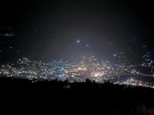 a view of a city lit up at night at Himalayan Whisper in Kulu +2 photos