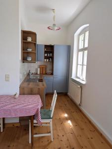 a kitchen with a table and a table and a window at Alte Dorfschule Sacro in Sacro +6 photos