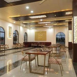 a room with tables and chairs in a building at The Emerald Palace in Sehore