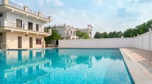 a swimming pool in front of a building at The Emerald Palace in Sehore +25 photos