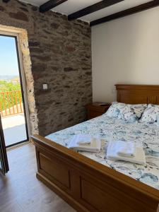 a bedroom with a bed with two towels on it at A casa do Avô Cruzes in Cerejais