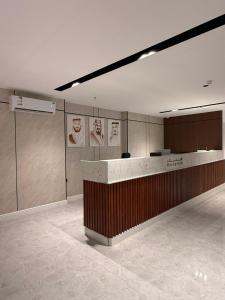 a lobby with a counter with posters on the wall at wifad Hotel in Al Namas
