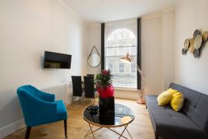 a living room with a couch and a table at Market Street Apartments - City Centre Modern 1bedroom Apartments with NEW WIFI and Very Close to Tram in Nottingham