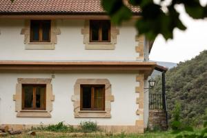 a house with three windows on the side of it at Los Jazmines de la Vega in La Vega