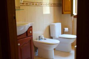 a small bathroom with a toilet and a sink at Los Jazmines de la Vega in La Vega