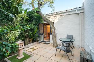 a patio with a table and a tree at Paradiso Guesthouse & Self-catering Cottage in Cape Town