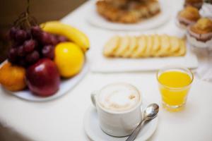 a table with plates of fruit and a cup of coffee at Hotel del Virrey in Luján +14 photos
