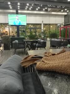a lobby with a tv and tables and chairs at صفاء هاوس in Fāriskūr al Balad