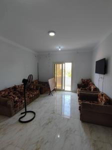 a living room with couches and a flat screen tv at صفاء هاوس in Fāriskūr al Balad