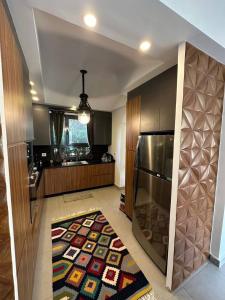 a kitchen with a refrigerator and a rug on the floor at صفاء هاوس in Fāriskūr al Balad
