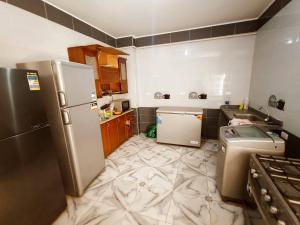 a kitchen with a refrigerator and a sink at صفاء هاوس in Fāriskūr al Balad