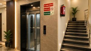 a elevator in a building with a sign on the wall at Hotel Namah Prime Near By Chanda Nagar Ameenpur Road in Hyderabad