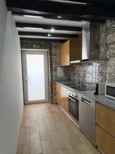 a kitchen with a door leading to a doorway at A casa do Avô Cruzes in Cerejais
