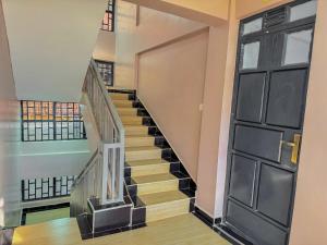 a staircase in a house with a black door at Riverview greenstar cozy homes in Kisii