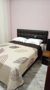 ein Schlafzimmer mit einem Bett mit schwarzem Kopfteil in der Unterkunft Hotel Jomaley in Loja + 11 Fotos