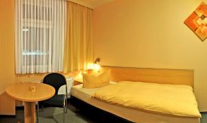 a hotel room with a bed and a table at Gasthof Schondelmaier in Oschersleben