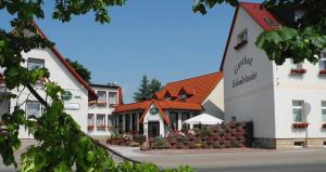 a large white building with a red roof at Gasthof Schondelmaier in Oschersleben