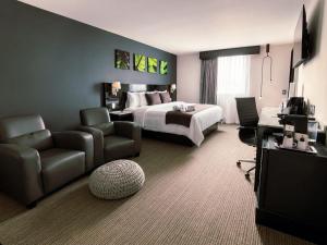 a hotel room with a bed and a couch and chair at LaiLa Hotel Mexico City Reforma in Mexico City