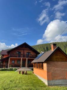 a large building with a grass yard in front of it at Casa Mona in Arieşeni