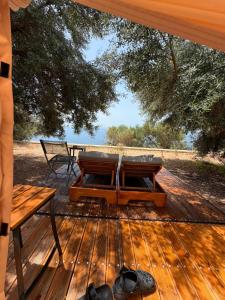 a wooden deck with a bench and a table at Cimarte The Path Lukove in Lukovë
