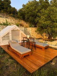 a wooden deck with two beds and a tent at Cimarte The Path Lukove in Lukovë
