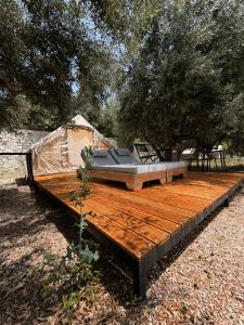 a bed on a wooden deck with a tent at Cimarte The Path Lukove in Lukovë