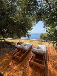 a wooden deck with two benches and a table at Cimarte The Path Lukove in Lukovë +49 photos